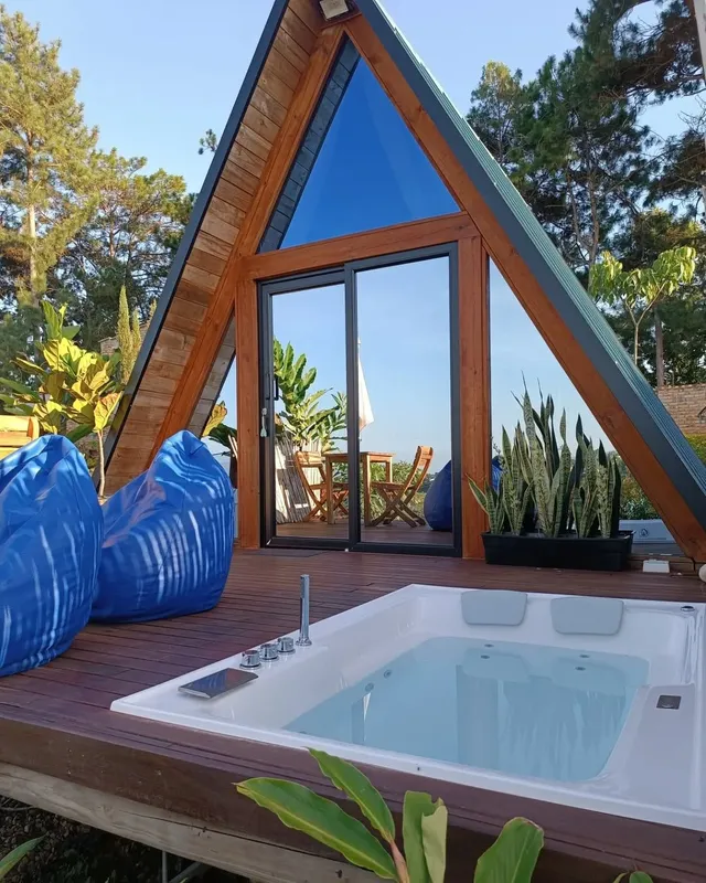 Cabaña tipo A-frame con jacuzzi exterior y terraza, experiencia de glamping con jacuzzi ideal para parejas.