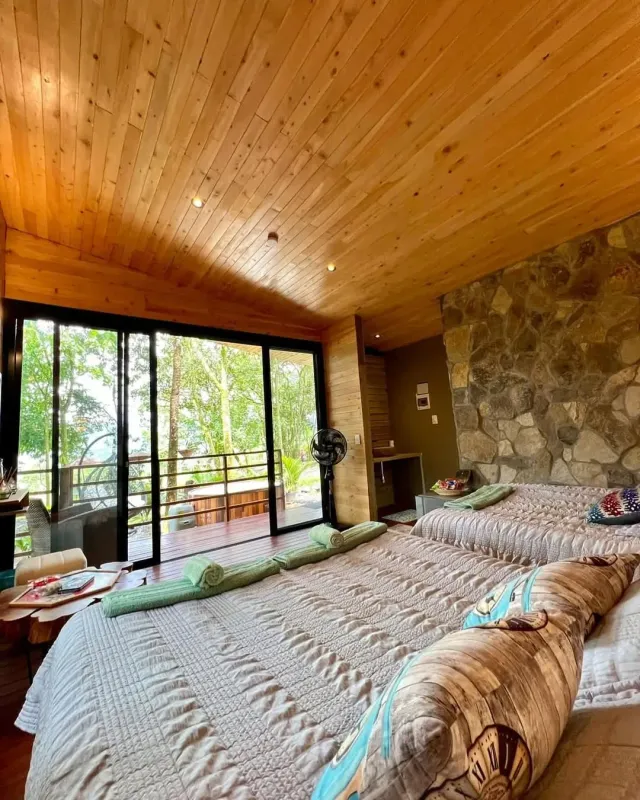 Habitación de cabaña de glamping en madera con camas dobles y ambiente cálido