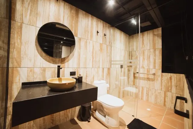 Habitación de hotel boutique con diseño moderno, cama king, área social y vista natural, ideal para glamping de lujo.