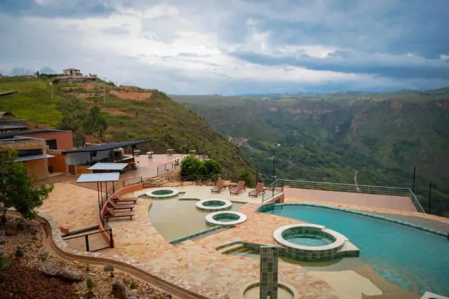 Complejo de glamping con piscina y vista al cañón verde en las montañas de Bucaramanga.