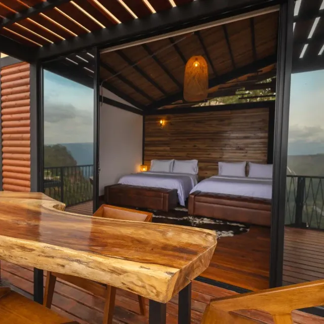 Habitación de hotel con dos camas, diseño en madera y ambiente cálido, ideal para cabaña de lujo y glamping.